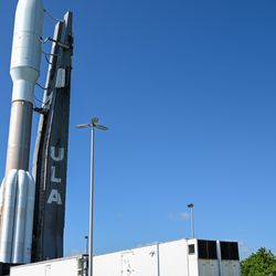 The rocket standing vertically from the ULA assembly building onto the launchpad