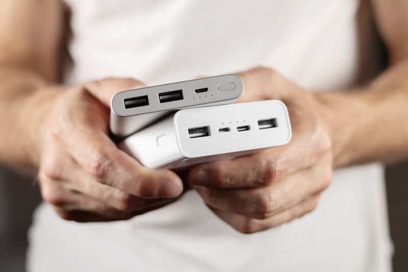 close-up of person holding two power banks in their hands