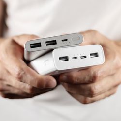 close-up of person holding two power banks in their hands
