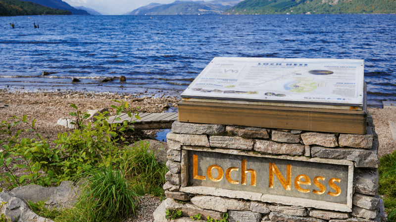a sign for loch ness in front of the loch